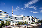 Contemporary buildings line the East bank of the Spree river, showcasing Berlin\'s vibrant architecture and the iconic television tower.