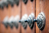 A close-up reveals the intricate design of a studded door at the historic Monastery of Santa Inés, showcasing its craftsmanship.