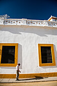 Seville, Spain Aug 15 2007, A man walks thoughtfully along the bright white walls of the Real Maestranza bullring in Seville under a clear blue sky.