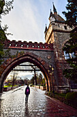 Young woman entering the gate of Vajdahunyad Castle, Budapest, Hungary