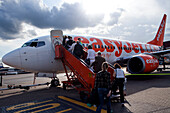 London, Großbritannien, 3. Mai 2009, Passagiere besteigen ein Flugzeug am Flughafen Luton, Großbritannien, bei teilweise bewölktem Himmel