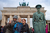 Berlin, Germany, July 24 2009, Visitors take photos with street performers dressed as former GDR soldiers near the iconic Brandenburg Gate in Berlin.