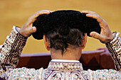 A bullfighter is seen adjusting his montera before performing in the ring at the iconic Real Maestranza in Seville on August 15, 2006.