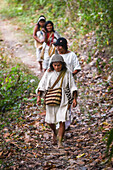 Kogi mamo (priest) and family walking through the forest.