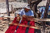 A man weaving on a wooden foot loom in Seclantas, Argentina in the Calchaqui Valley.