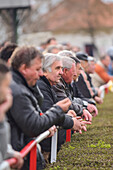 People watching a soccer youth game in small town of Hungary