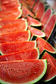 Colorful slices of watermelon are displayed at Mercado de la Boquería, inviting visitors to enjoy a refreshing treat.