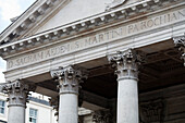 The ornate columns and inscriptions of St Martin in the Fields church highlight Londons architectural beauty against the skyline.