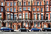 Explore the beautiful architecture of Victorian houses lining Pont Street in Kensington, showcasing their iconic red brick facades.