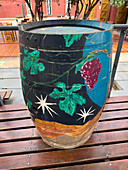 Painted wine barrel in the courtyard of the Museo de la Vid y el Vino or Museum of the Vine and the Wine in Cafayate, Argentina. The painting has a wine-making motif.