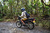 Young man riding motorbike in Sierra Nevada de Santa Marta, Colombia