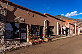 Shops and restaurants along Libertad Street in Purmamarca, Argentina, with the Hill of Seven Colors behind at right.