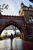 Young woman entering the gate of Vajdahunyad Castle, Budapest, Hungary