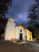 Facade of the Church of Santa Rosa de Lima lit up at night in Purmamarca, Argentina.