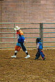 Ein junger Cowboy folgt einem Rodeo-Clown, nachdem er beim Moab Junior Rodeo in Moab, Utah, ein bockendes Pony geritten hat