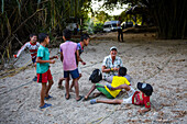 Group of playful local kids having fun with a foreigner woman, Santa Marta, Colombia