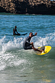 Surfers in Grande Plage beach of Biarritz, France