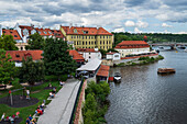 Left bank of Vltava river in Prague with mouth of Certovka stream, old houses and former complex of Herget's brickworks, now a restaurant and museum