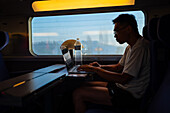 Silhouette of man working with his laptop in the high speed AVE train, Spain