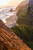 Young woman walking on the beach in front of Finca Barlovento at sunset, Tayrona National Park, Colombia