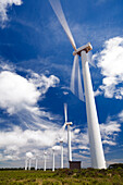 Wind turbines spin under a bright sky near Sagres, showcasing renewable energy production in the Vila do Bispo region.