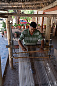 A man weaving on a wooden foot loom in Seclantas, Argentina in the Calchaqui Valley.