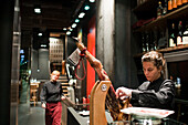 Barcelona, Spain, Sept 4 2008, A chef expertly slices Iberian ham while other staff observe in a sleek, modern restaurant setting in Barcelona, Spain.