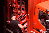 Ein Coca-Cola-Lieferant nimmt Flaschenkisten in einer Straße von San Lorenzo de El Escorial in der Gemeinde Madrid entgegen