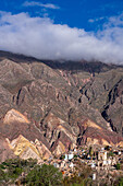 Tombs in the Our Lady of Carmen Cemetery in Maimara in the Humahuaca Valley or Quebrada de Humahuaca, Argentina. Behind is the Painter's Palette, a colorful geologic anticline.