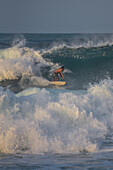 Man surfing on the beach in front of Finca Barlovento, Tayrona National Park, Colombia