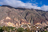 Gräber auf dem Friedhof Our Lady of Carmen in Maimara im Humahuaca-Tal oder Quebrada de Humahuaca, Argentinien. Dahinter befindet sich die Painter's Palette, eine farbenfrohe geologische Antiklinale