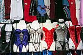 A vibrant display of various lingerie styles showcased at a stall in Mercado de San Antonio, Barcelona, inviting shoppers to browse.