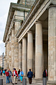 Berlin, Germany, July 24 2009, People walk by the impressive columns of the Brandenburg Gate, a famous landmark in central Berlin, Germany, on a vibrant day.