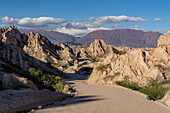 Route 40, an unpaved dirt road through the eroded landscape of the Angastaco Natural Monument in the Calchaqui Valley, Argentina.