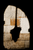 The shadow of a street lamp over a wall in Segovia Main Square.