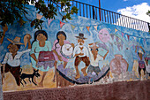 A wall mural depicting people crushing grapes with their feet to make wine in Cafayate, Argentina.