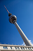 The iconic Fernsehturm towers above the Berlin skyline, showcasing its distinct design against a clear blue sky.