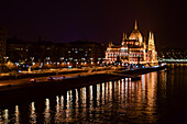 Illuminated Parliament building and Danube River it night, Budapest, Hungary, Europe