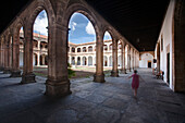 Salamanca, Spain, Aug 17 2008, A visitor walks through the historic cloister of Colegio Arzobispo Fonseca, enjoying the serene architecture and clear blue skies.