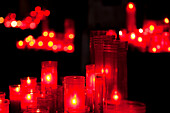 The soft glow of red votive candles fills the serene interior of Santa María del Mar, creating a contemplative atmosphere.