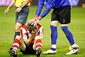 Seville, Spain, Feb 4 2009, Gorka Iraizoz helps teammate Llorente, who is on the ground after getting injured, during the 2009 Copa del Rey semifinal match.