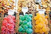 Brightly colored candies are artfully arranged in baskets at Mercado de la Boquería, inviting visitors to indulge in sweet treats.