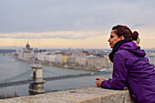 Young woman enjoying the skyline, including Parliament building and Danube River, Budapest, Hungary, Europe