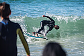 Surfers in Grande Plage beach of Biarritz, France