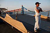 Seville, Spain, Aug 7 2008, A sailor waits on the barge for passengers at Bajo de Guia beach along the Guadalquivir river in Sanlucar de Barrameda, Cadiz.