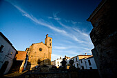 The historic Iglesia de Santa María de Almocóvar stands proudly against a twilight sky in Alcántara, reflecting its rich heritage.