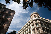 Historische Architektur säumt die Carrer Gran de Gracia und zeigt komplizierte Details vor einem strahlend blauen Himmel im Stadtteil Gracia