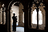 Barcelona, Spain, Sept 4 2008, A visitor stands in the cloister of Sant Pau del Campo, capturing its historical architecture during a serene moment.