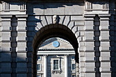 The arch at Trinity College showcases stunning stonework with a view of the classic building and clock, highlighting Dublins rich history.