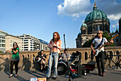 The Benka Boradovsky Bordello Band entertains passersby on Friedrich Bridge with vibrant music near Berlin\'s Cathedral.